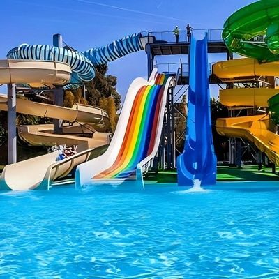 Bambini in piscina in terra cavalcare scivolo in fibra di vetro per parco acquatico